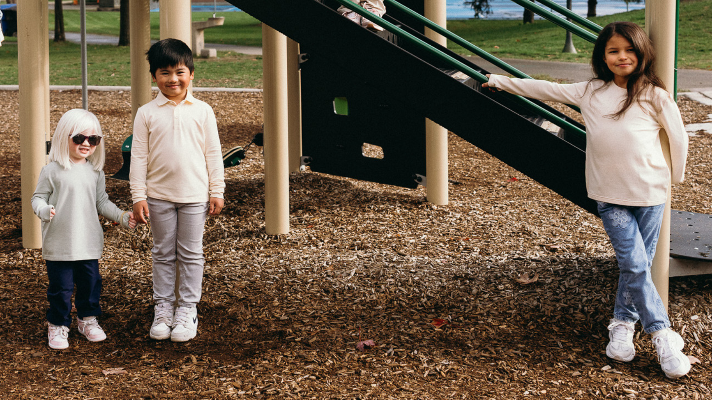 Child wearing Ember & Ray UPF 50+ clothing outdoors on a sunny day, showing everyday sun protective clothing for kids